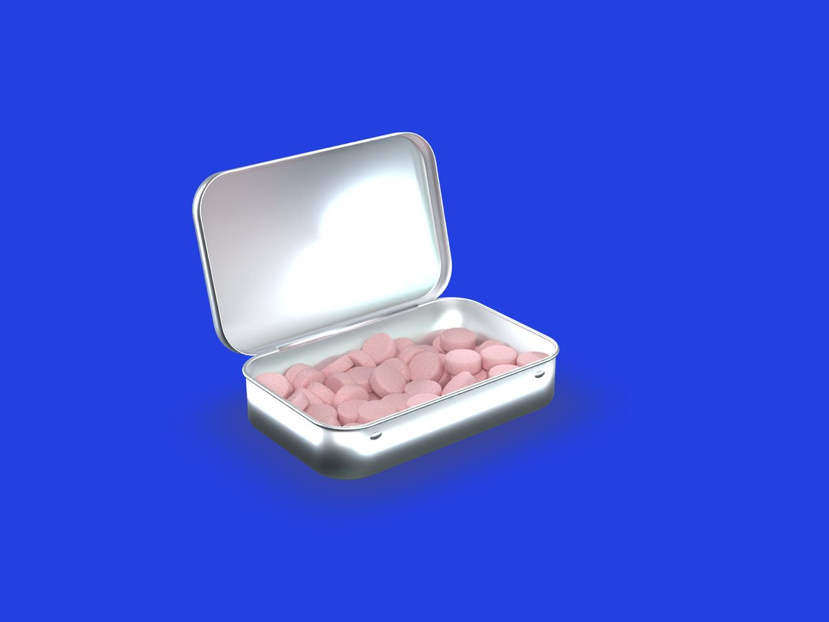 An open tin filled with strawberry caffeinated mints